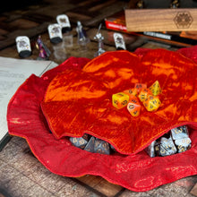 Load image into Gallery viewer, A bright orange and red dice bag lays open on a D&D map.