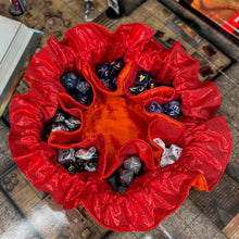 Load image into Gallery viewer, A bright orange and red dice bag sits open on a D&D map.