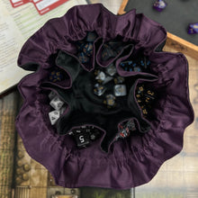 Load image into Gallery viewer, A black and purple dice bags sits open on a gaming table.