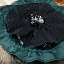 Load image into Gallery viewer, A black and green dice bag sits open flat on a gaming table.