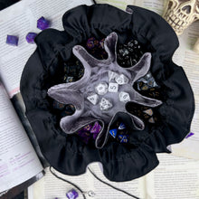 Load image into Gallery viewer, A silver and black dice bag is open on top of D&amp;D game books. Inside, the pockets are full of colorful dice.
